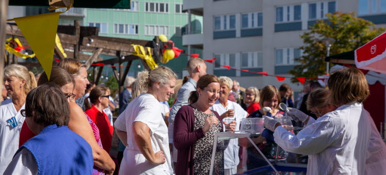 Folksamling med ballonger och vimplar.