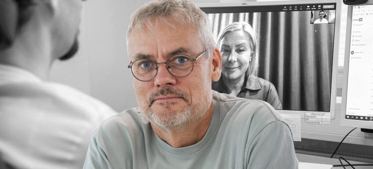 Bild på Pär Eriksson som tittar in i kameran. I bakgrunden syns en datorskärm där en kvinna är med i ett digitalt möte.