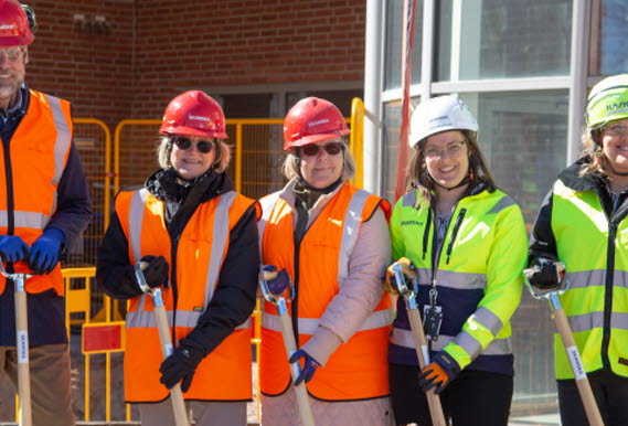 Mattias Adolfson, regionråd, Katarina Lindeblad, barnsköterska, Carina Karlsson, sjuksköterska, Emma Igelström, från Skanska och Anna Holmström, byggprojektledare på regionfastigheter tar ett första spadtag i jordhög med sina spadar.