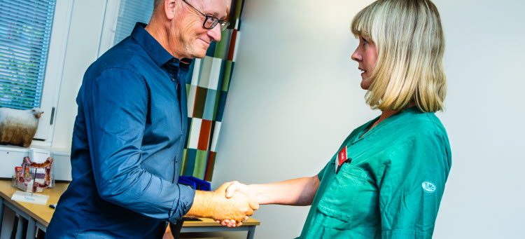 Handslag mellan vårdanställd och patient.