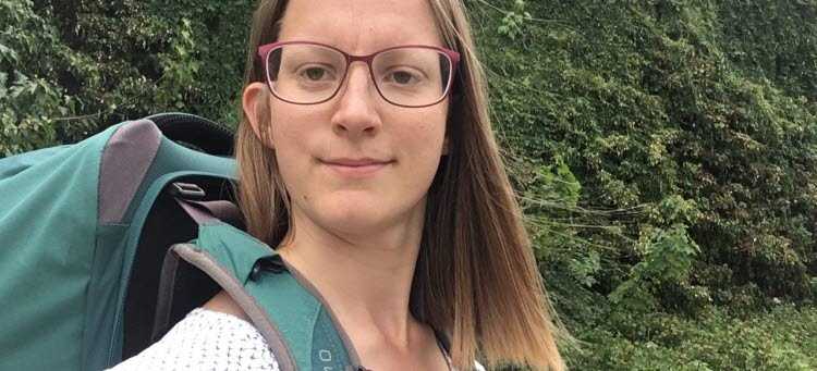 Johanna Wennberg står framför ett buskage med den ryggsäck hon använde under uppdraget som testresenär.
