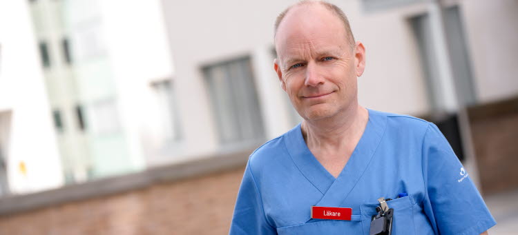 Johan Liliequist står i blåa sjukvårdskläder utanför Västerviks sjukhus.