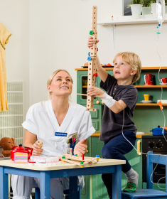 Sjuksköterska och pojke i ett lekrum