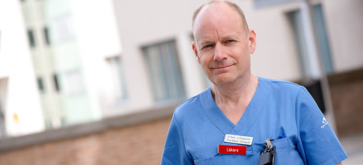Johan Liliequist står i blåa sjukvårdskläder utanför Västerviks sjukhus.